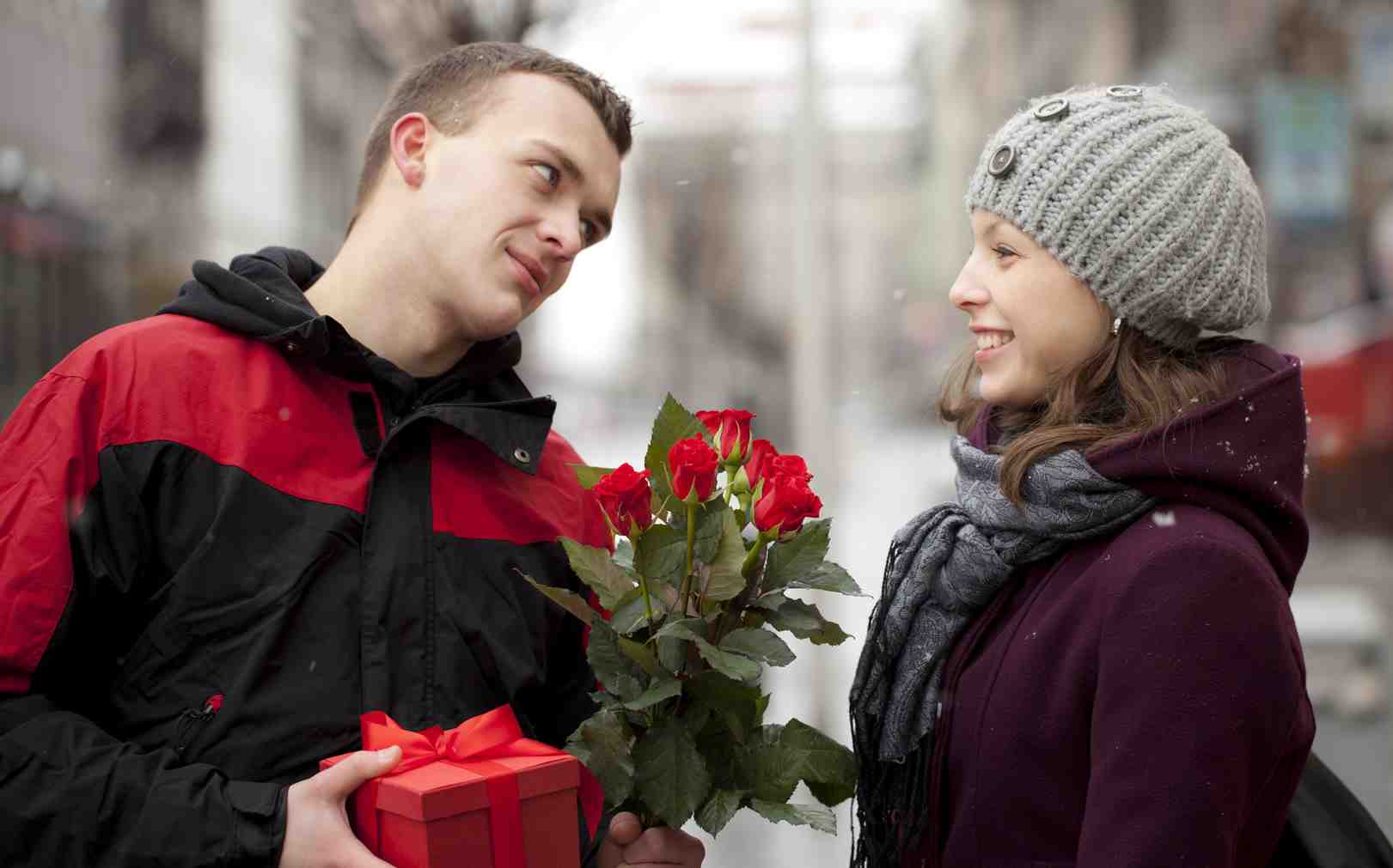 8 января мужчина. Молодой человек дарит цветы. Мужчина дарит цветы женщине. Парень дарит девушке цветы. Девушке дарят цветы.